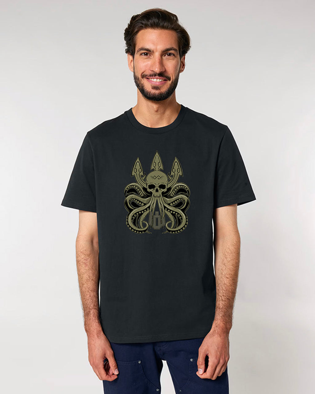 Man wearing a black t-shirt with a skull and octopus design on a plain background