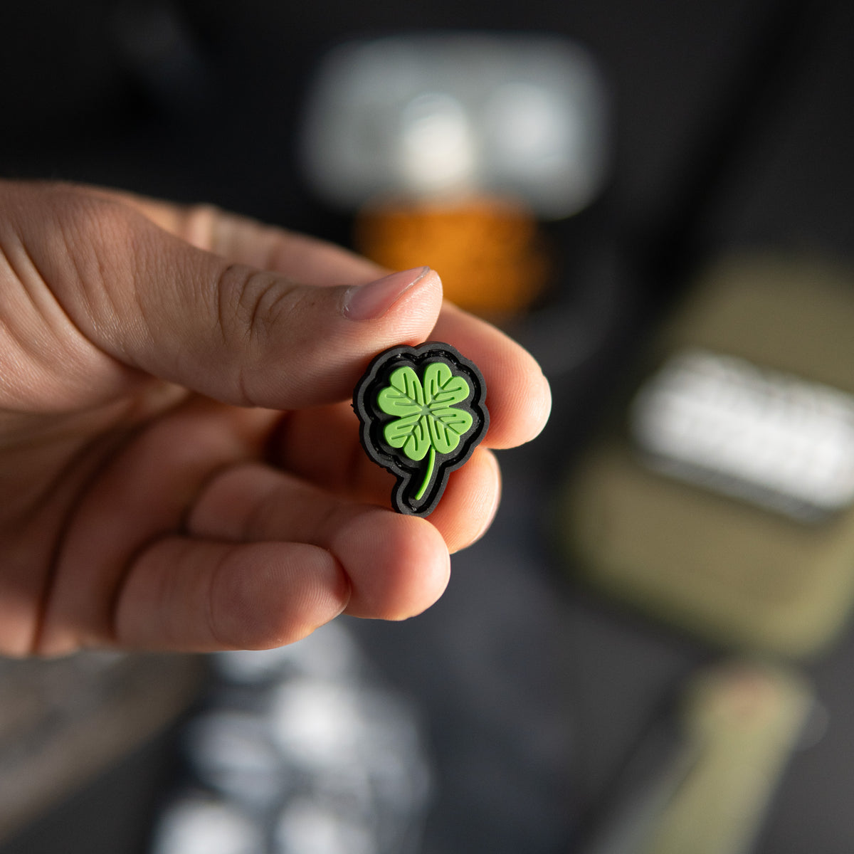 Clover PVC morale patch with green four-leaf clover design held in a hand
